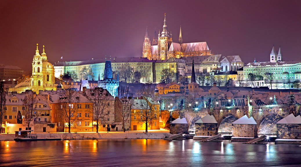 Night snowy Prague gothic Castle and St. Nicholas' Cathedral with Charles Bridge