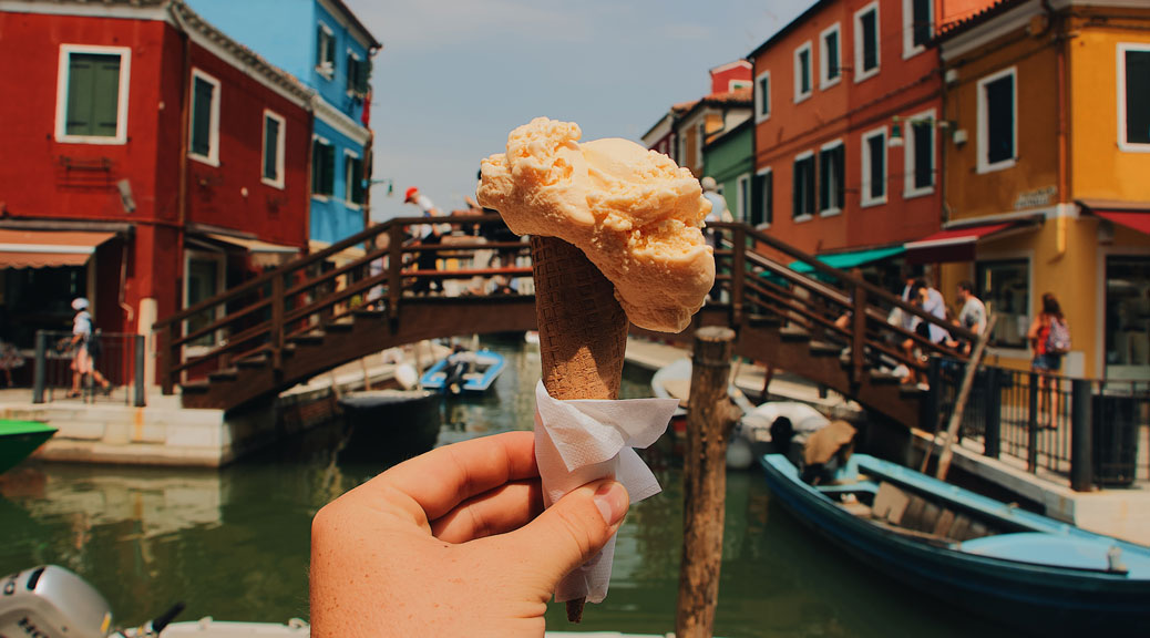 Hand man holds an Italian ice cream on background of Grand Canal in Venice, Italy