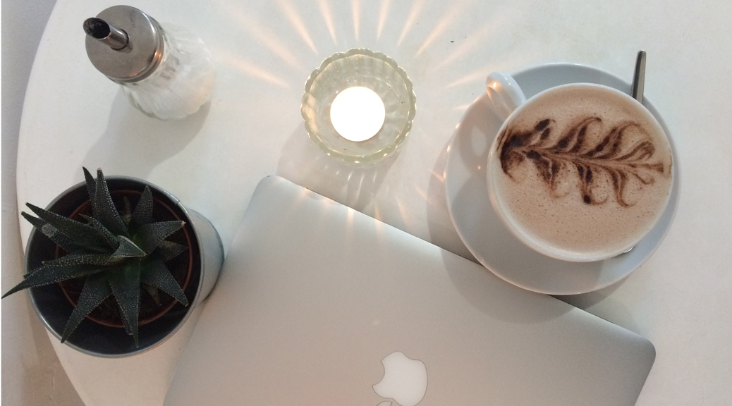 A macbook and coffee on a table