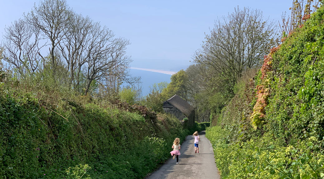 Two kids running towards a garden