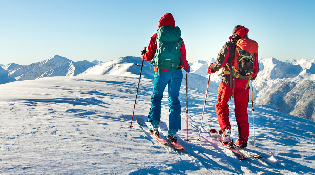 Man and woman skiing together enjoying the view on a summit.