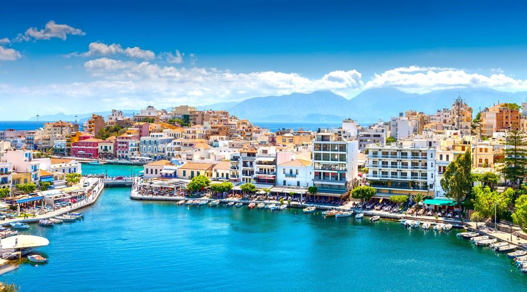picturesque town of agios nikolaos with colourful buildings and boats stacked on its bay