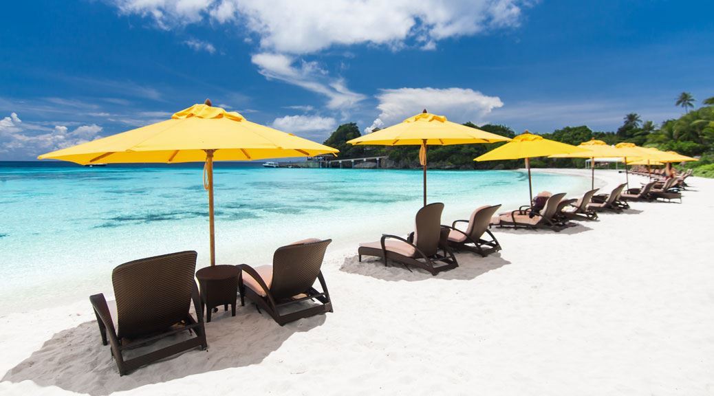Sun umbrellas and chairs on tropical beach on white sand in cancun