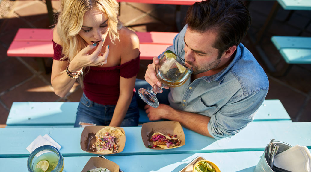 couple eating authentic street tacos at outdoor mexican restaurant 