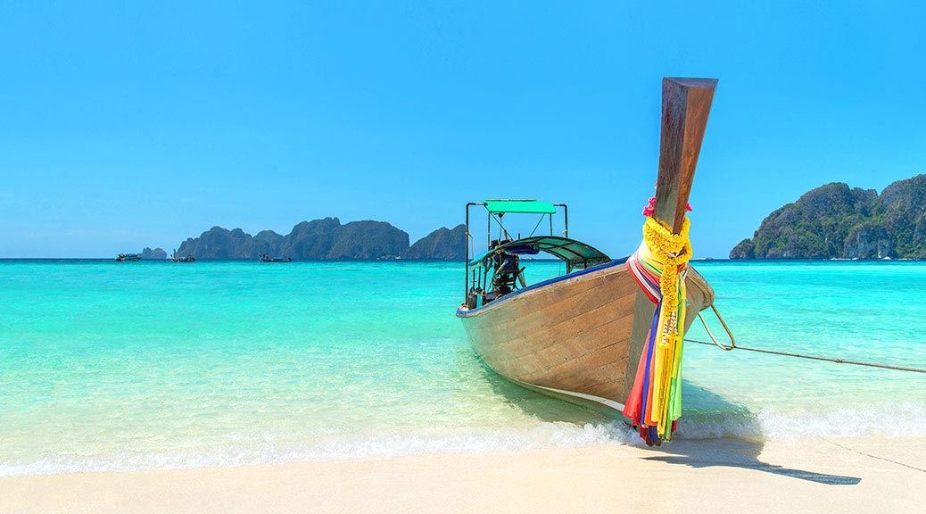 traditional thai boat at the bank of the sea on the beach