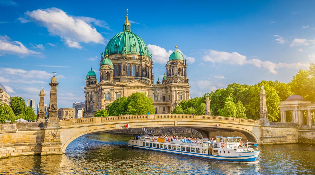 view of Berliner Dom at Museum Island with excursion boat on Spree river in beautiful evening light at sunset in Berlin