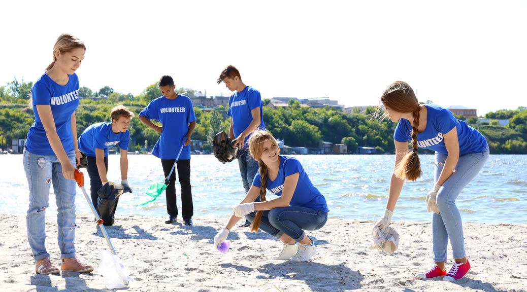 Group of young people cleaning beach area