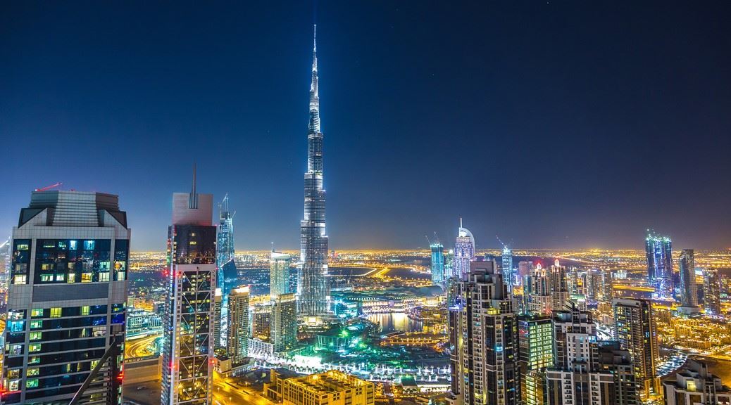 Dubai downtown lit up in lights at night and burj khalifa seen in the middle