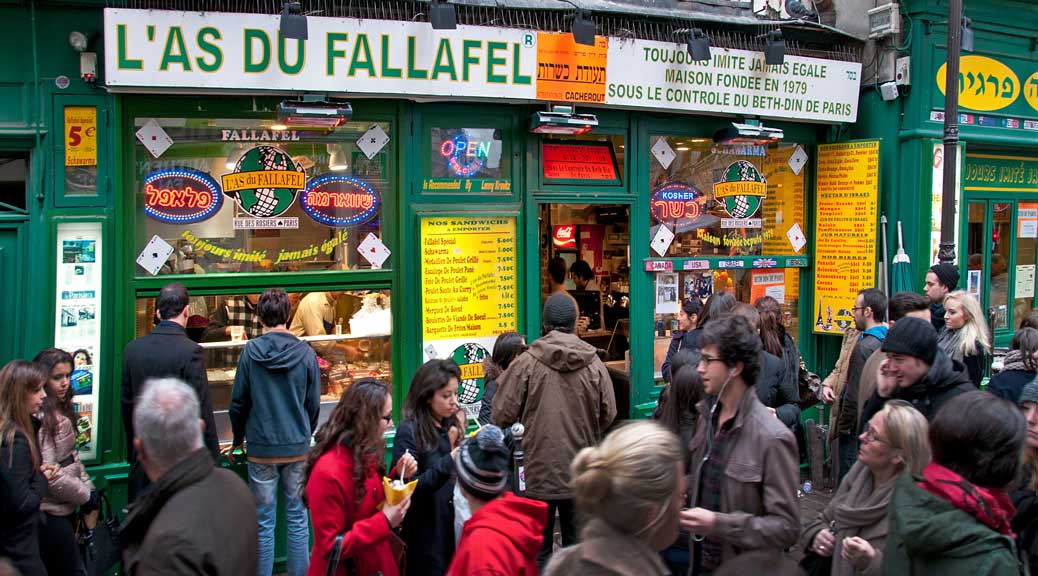 tourist enjoying street food in a famous food centre l&#039;as-du-fallafel paris