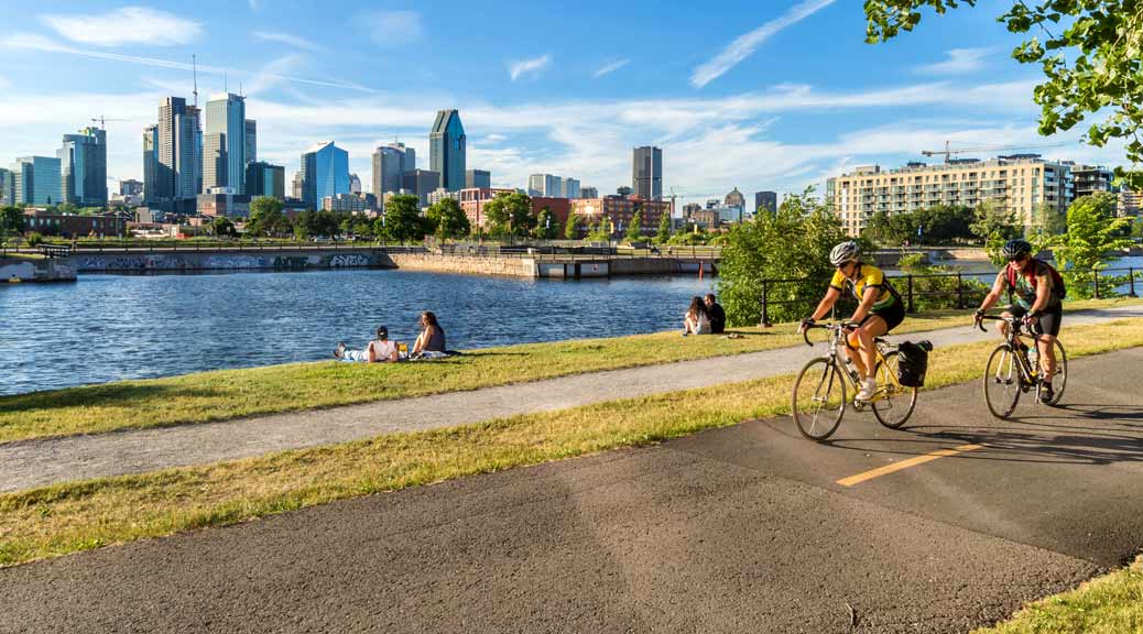people riding bicycles on lachine canal’s bike path in montreal