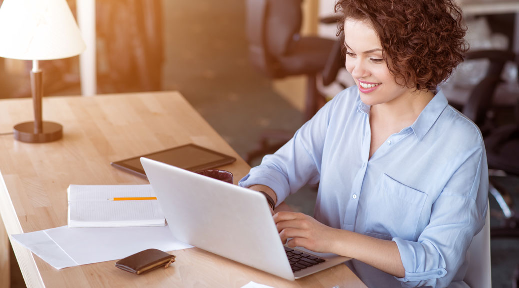 Pleasant woman searching on laptop for last minute deals