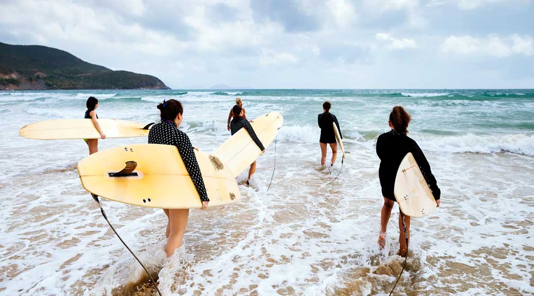 women surfers with surfing boards 